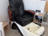 a black and white reclining chair and a fan in a room