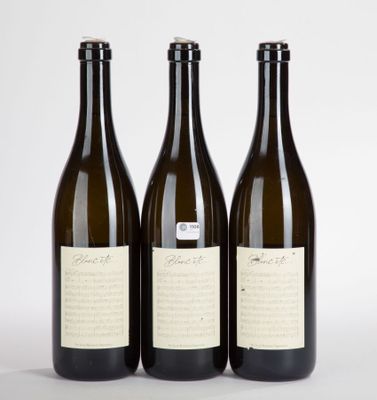 trois bouteilles de vin posées les unes à côté des autres sur une surface blanche