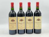 trois bouteilles de vin rouge sont alignées sur une surface blanche