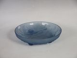 a blue glass bowl sitting on a white surface