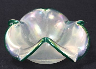 a green and white glass bowl on a black surface