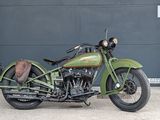 a green motorcycle parked in front of a garage door