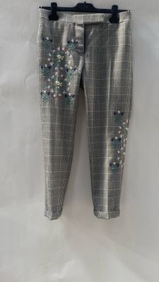 the pants have sequins on them and are hanging on a hanger