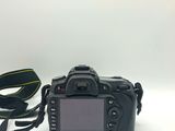 the camera is sitting on a white surface with a strap around it