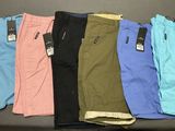 Plusieurs paires de pantalons pour hommes sont alignées sur une table