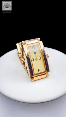 une montre en or posée sur une assiette blanche, sur une table