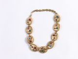 a close up of a gold necklace with multi colored stones