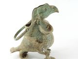 bronze figurine of a bird with a bag on its back