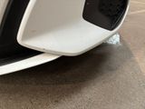 a close up of a white car ' s front bumper