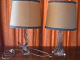 two lamps that are on a table in front of a curtain