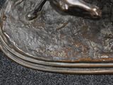 a bronze statue of a man holding a tennis racquet