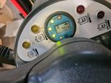 a close up of a steering wheel with a clock on it