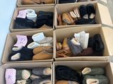plusieurs paires de chaussures dans une boîte posée sur le sol