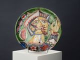 a plate with a painting on it on a pedestal