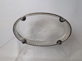 a clear glass bowl with a silver rim on a clear table