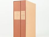 two books are stacked on top of each other on a white surface