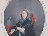 portrait of a woman sitting in a chair with a vase of flowers in the background