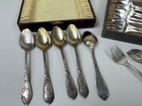 a lot of silver spoons and silverware on a table