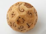 a wooden dice with numbers on it on a white surface