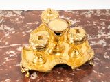 a gold candle holder on a marble table