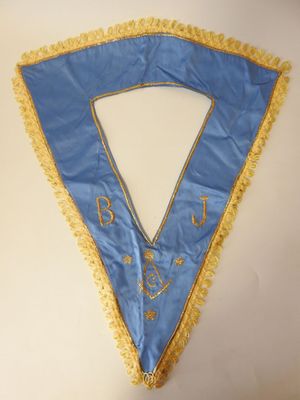 un gros plan sur une écharpe bleue et jaune bordée d'or