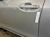 a silver car with a sticker on it ' s door handle
