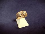 a close up of a gold ring with three diamonds on a piece of paper
