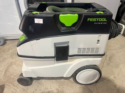 a green and black dust extracter sitting on the floor