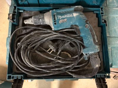 une boîte bleue contenant un cordon et une perceuse