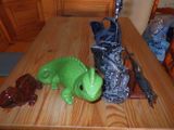 une statue d'alligator vert posée sur une table, à côté d'un couteau et d'un sac