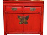 an image of a red cabinet with two drawers and a butterfly on the door