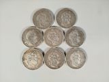 six different british coins sitting on top of each other on a white surface