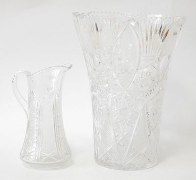 two glass vases sitting next to each other on a white surface