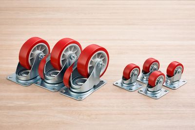 un ensemble de quatre chaises Casteor rouges posées sur un parquet
