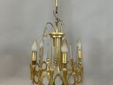 an antique brass chandelier with clear glass drops hanging from the ceiling