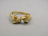 un gros plan d'une bague en or ornée de deux crânes