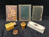 quatre livres, une boîte, une bougie et un bougeoir posés sur une table