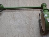 une lampe verte accrochée au mur à côté d'une lampe