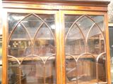 a large wooden cabinet with glass doors in a room