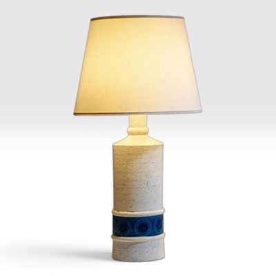 un gros plan d'une lampe posée sur une table, avec un abat-jour blanc
