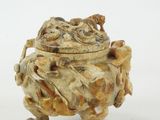 a small carved object on a white surface
