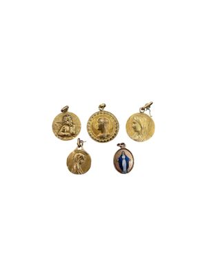a group of four gold - plated medallions of jesus and other religious symbols