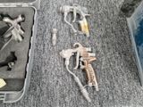 une arme à feu et d'autres objets dans une mallette posée par terre