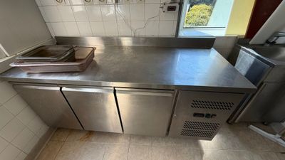 a stainless steel counter top in a kitchen with a window