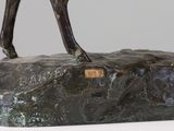 bronze statue of a horse standing on a rock on a white surface