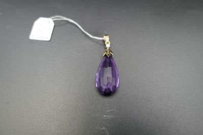 un pendentif en forme de larme en amethorate est suspendu à un cordon