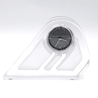 une horloge posée sur un socle transparent