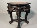 an ornately carved table with a marble top on a white background
