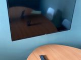 une télévision à écran plat accrochée au mur au-dessus d'une table