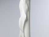 sculpture of a woman ' s torso on a base on a white surface